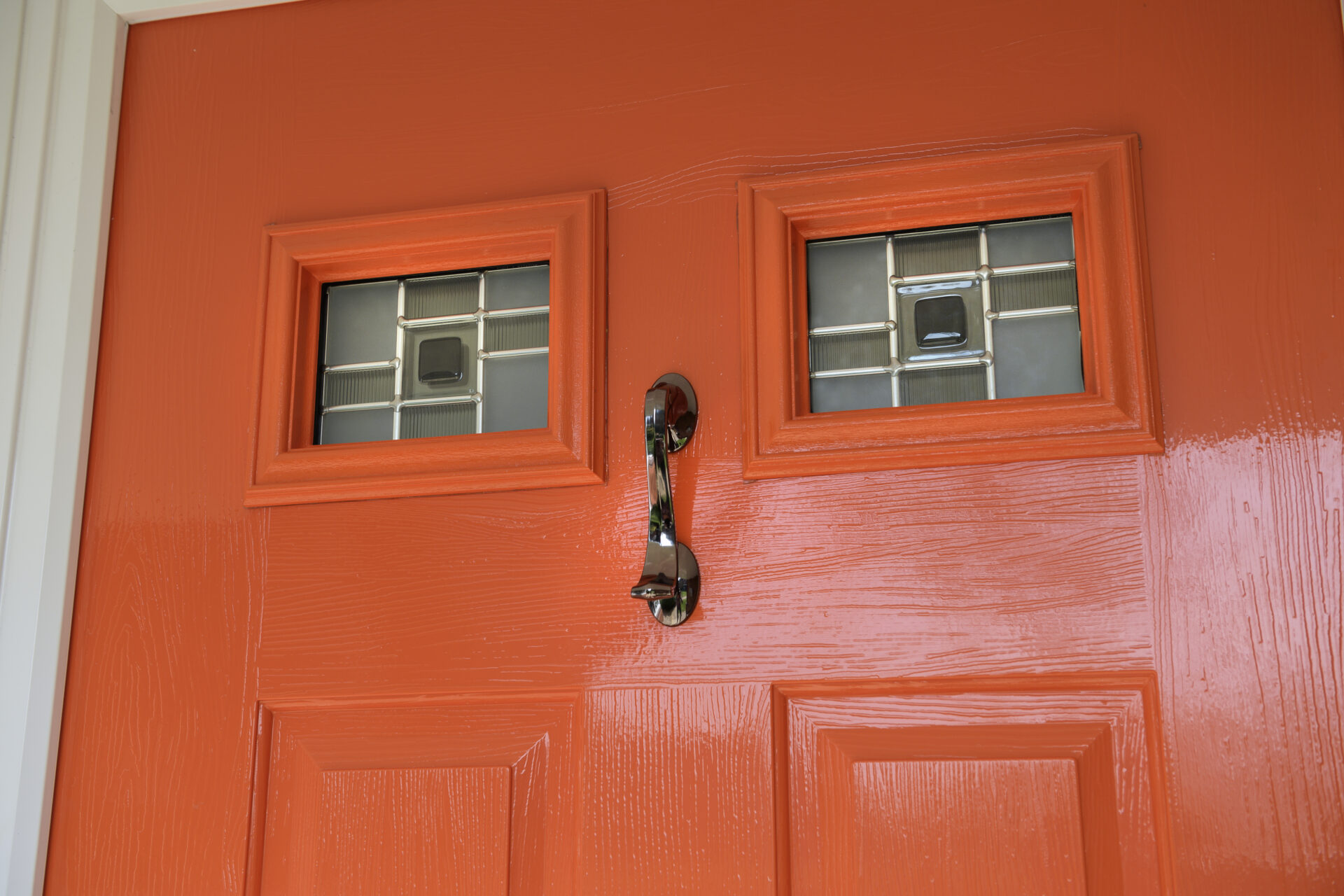 Solidor : Tangerine solidor composite door close up with 2 small windows and a knocker