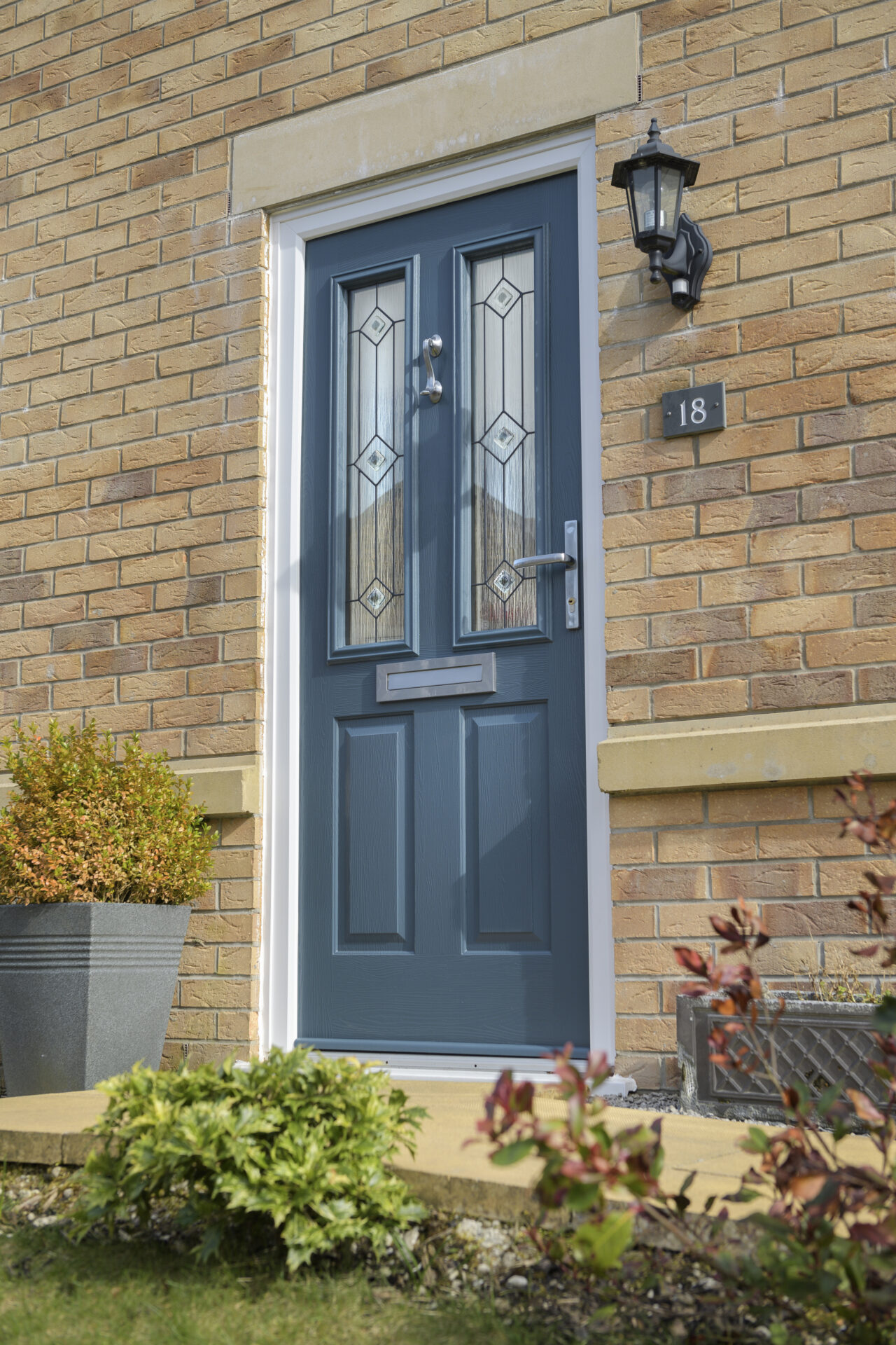 solidor vs rockdoor: Solidor installed as an entrance door with plant pots next to the door.