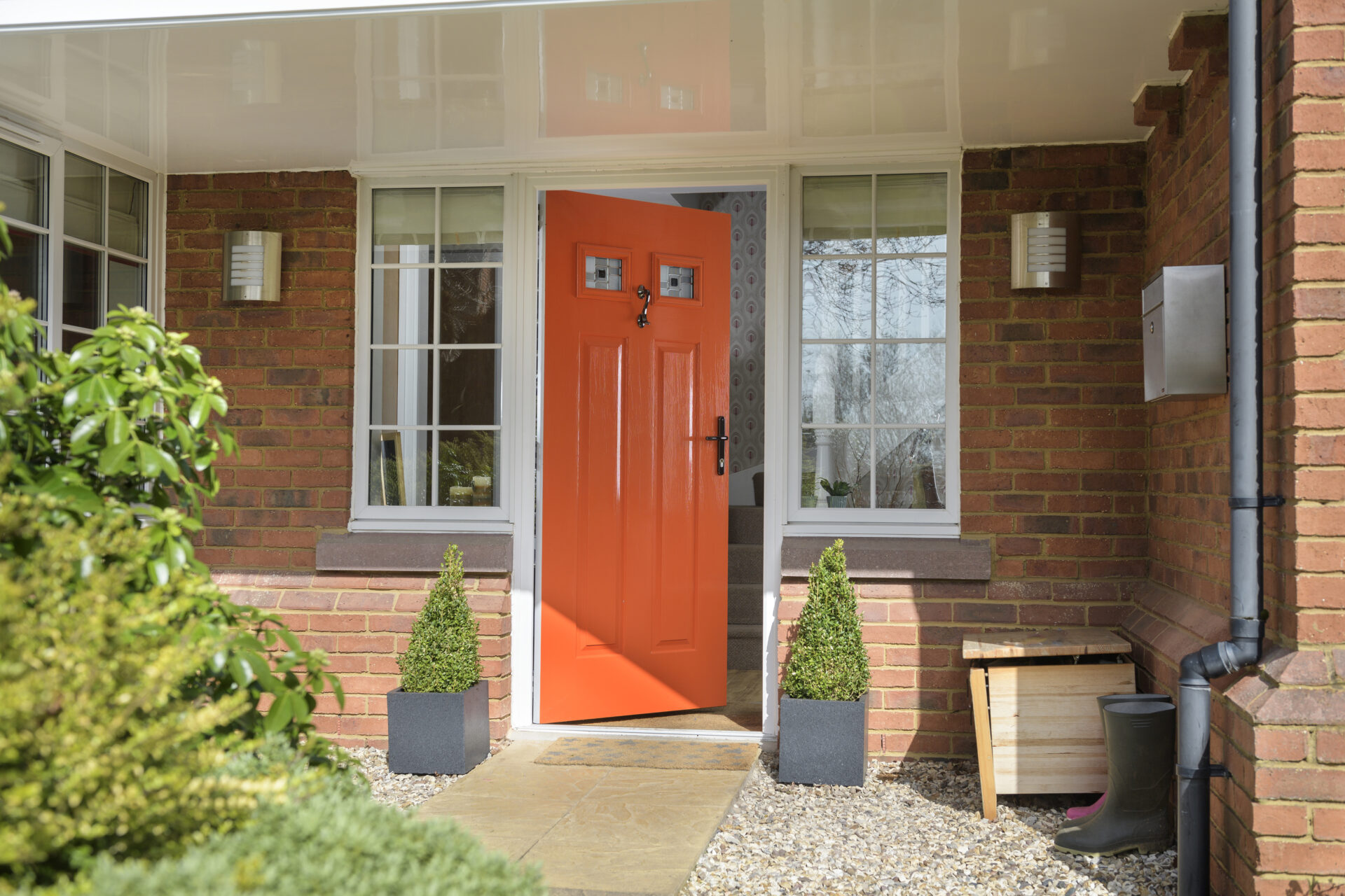 how to make your home more energy efficient: exterior shot of a bright orange door that has ajar