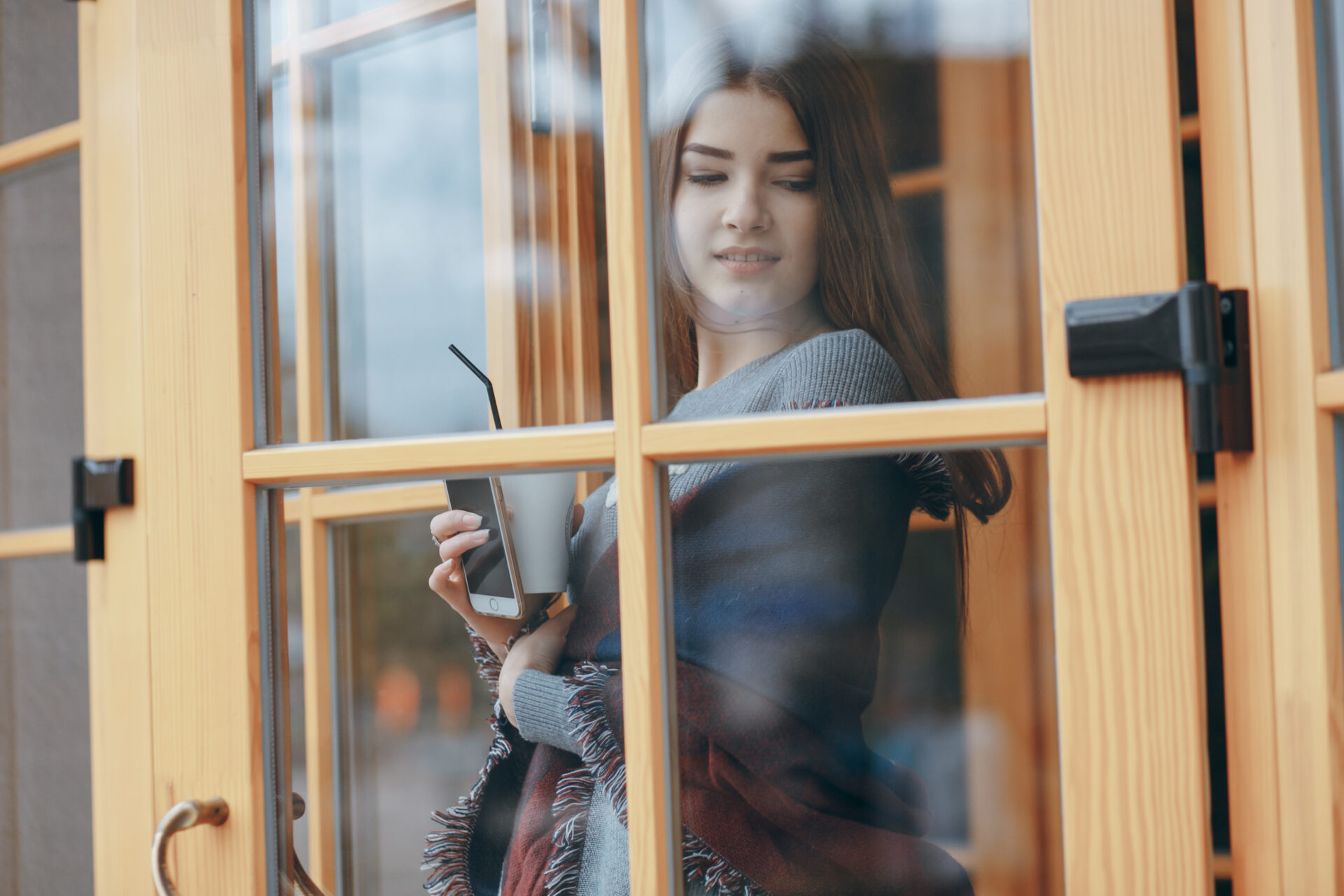 Lady pushing open a double glazed door.