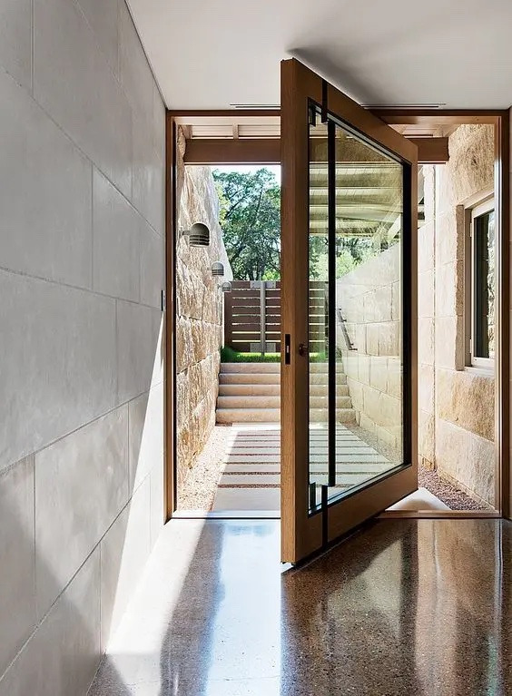alternative to bifold doors: Pivot entrance door half opened.